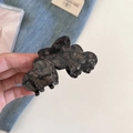 Dettaglio di un fermaglio per capelli in acetato con motivo marmoreo scuro e tre cuori - Stile a 3 Cuori / Nero Marmorizzato