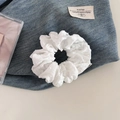 Dettaglio di scrunchie bianco con trama jacquard a pois 3D ed etichetta del marchio - Stile a Pois in Filato di Cotone