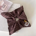 Coletero retro de cuadros rojo y marrón con etiqueta de marca sobre libros vintage - Coletero Bandana Rojo Café
