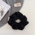 Dettaglio dell'elastico per capelli nero plissettato con etichetta bianca in tessuto - Nero
