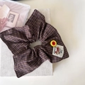 Detalle de coletero retro de cuadros marrones con etiqueta de perro y botón amarillo - Coletero Bandana Púrpura Café