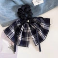 Détail d'un chouchou à carreaux bleus avec ruban satiné et pendentif en cœur - Style Ruban Marine