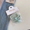 Vue détaillée d'un élastique à cheveux vert menthe avec perles en résine sur fond denim - Vert Clair