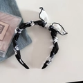 Détail du serre-tête torsadé à imprimé noir et blanc avec nœud et pinces à cheveux - Style Nœud Torsadé / Imprimé Noir et Blanc