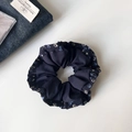 Detail von marineblauem Haargummi mit Blumenmuster auf plissiertem Chiffon-Stoff - Plissee-Blumenstil / Dunkelblau