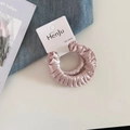 Detailweergave van roze satijnen haarelastiekjes met elegante glanzende textuur en elastiek - Geplooide Scrunchie / Lichtroze