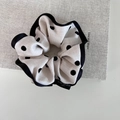 Detail showing white polka dot scrunchie fabric and embroidered textile brand label - 1# Creamy White