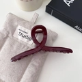 Macro shot of minimalist burgundy hair claw clip with glossy twisted design on linen background - Large Cross Style