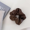 Détail d'un chouchou en cuir marron foncé avec des plis doux et une texture haut de gamme - Grand / Marron