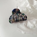 Close-up of a medium acetate shell hair claw with colorful marble texture and hollow design - Dark Blue Mixed Color