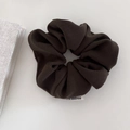Detail of dark coffee corduroy scrunchie texture with a white woven label on white background - Coffee Green-Large