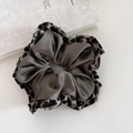 Detail view of large satin scrunchie with leopard print ruffle and grey inner fabric - Green
