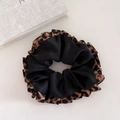 Detailed view of large leopard print scrunchie with layered satin and ruffled edges - Black