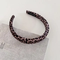 Detail of leopard print velvet headband with handmade label on a textured book - Light Leopard Narrow Style