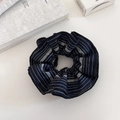Dettaglio di elastico per capelli blu scuro a righe con motivo etnico su tavolo - Blu Scuro