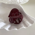 Detail view of a burgundy geometric triangle hair claw clip on a white textured tray - Small Pumpkin Shape - Red