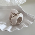 Detail view of cream-colored resin shark hair claw clip with durable metal spring mechanism - Small Pumpkin Shape - White