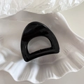 Macro shot of minimalist black triangle hair claw with cutout on shell tray - Small Semi-circle Shape - Black