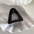 Macro shot of a black geometric triangle hair claw clip on a white shell plate - Small Triangle Shape - Black