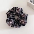 Gros plan détaillé d'un chouchou vintage à carreaux avec motif écossais classique noir et blanc - Chouchou Carreaux Noir Rouge