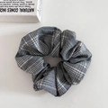Detail eines grauen Haargummis mit Karomuster aus weichem Stoff im Vintage-Stil - Grauer Karierter Scrunchie