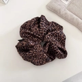Close-up of leopard print satin scrunchie with soft fabric texture and elegant folds - Leopard Scrunchie