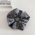 Detail eines grauen Haargummis mit Karomuster und funkelnden Strasssteinen darauf - Strass Grauer Karierter Scrunchie