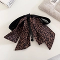 Detail view of stylish leopard print banana hair clip with elegant black satin bow accents - Leopard Ribbon Banana Clip