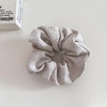Close-up of oatmeal wool fabric hair scrunchie with detailed woven texture and soft feel - Off White