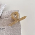 Detail of medium acetate hair claw in beige marble texture with silver spring mechanism - Creamy Apricot
