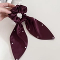 Dettaglio dell'elastico in raso bordeaux con perle bianche e lunghi nastri eleganti - Rosso Ancorra