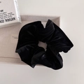 Close-up of black velvet scrunchie texture and pleated cloud design on beige tray - Black