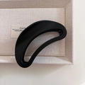 Dettaglio molletta per capelli a mezzaluna nera opaca su vassoio in tessuto di lino - Matte Bright Black