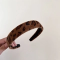 Détail d'un serre-tête en peluche léopard avec fausse fourrure et doublure noire antidérapante - Léopard Café Foncé