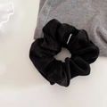 Dettaglio ravvicinato di un elastico per capelli in velluto nero con fibbia in metallo argento - Nero