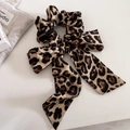 Detail eines Satin-Haargummis mit Leopardenmuster und langer Schleife auf weißem Grund - 2# Khaki Leopard