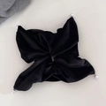 Elegant black velvet hair scrunchie with pearl accents and bow-style design on beige background - Black