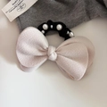 Dettaglio dell'elastico per capelli con fiocco in lana rosa, perle lucide e logo in metallo - Bianco Sporco