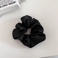 Detailed view of large black satin scrunchie with soft pleated texture and silk sheen - Black