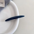 Nahaufnahme der minimalistischen dunkelblauen Acetat-Haarklammer auf weißem Teller - Blau