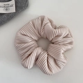 Detail of beige ribbed fabric scrunchie showing fine pleated texture and soft material - Off-white