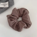 Close-up of brown pleated scrunchie with fine vertical stripe texture and elastic fabric - Milk Coffee