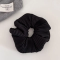 Macro shot of black pleated fabric scrunchie texture with stylish ribbed details - Black