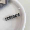 Detailed view of acetic acid heart-shaped hair clip with cow pattern on white plate - Black White Spotted