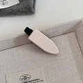 Close-up of matte beige rectangular hair clip in a decorative ceramic display tray - 1# Creamy White