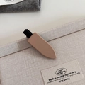 Macro view of a matte milk tea color PU leather duckbill hair clip on fabric background - Khaki