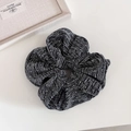 Dettaglio dell'elastico per capelli nero e argento luccicante con etichetta logo in tessuto - Scrunchie plissettati / Grigio