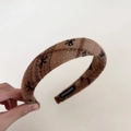 Detail of brown plaid wool headband with black bow embroidery and handmade label - Brown Plaid