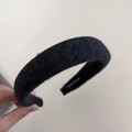 Detalle de la diadema acolchada de lana negra mostrando la textura suave y la inscripción - Gris Oscuro