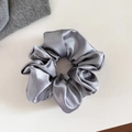 Vue détaillée d'un chouchou en satin gris argenté avec une texture plissée élégante - Grand / Gris